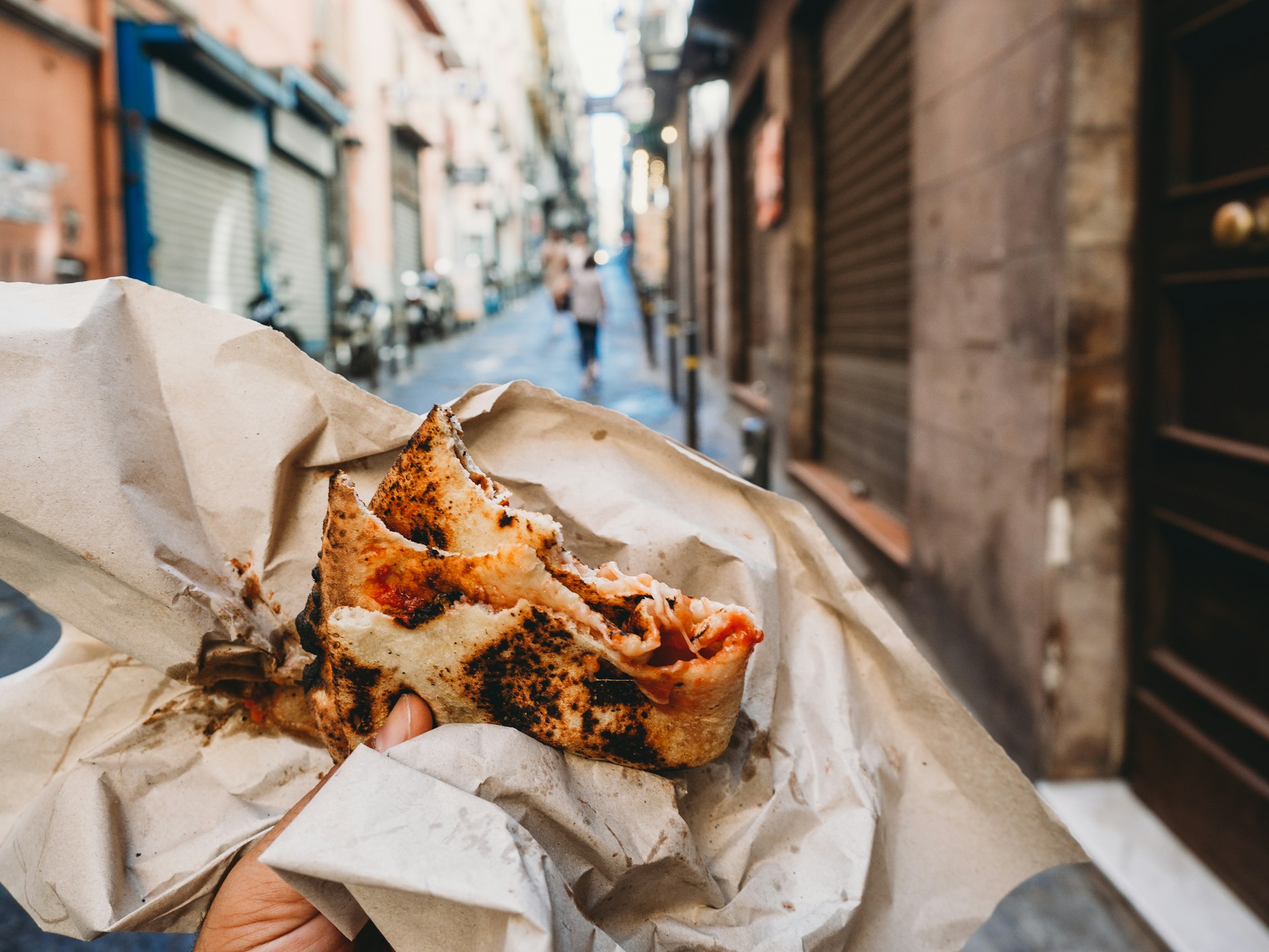 Pov view of a man eating a typical "Pizza a portafoglio" in Naples, Italy