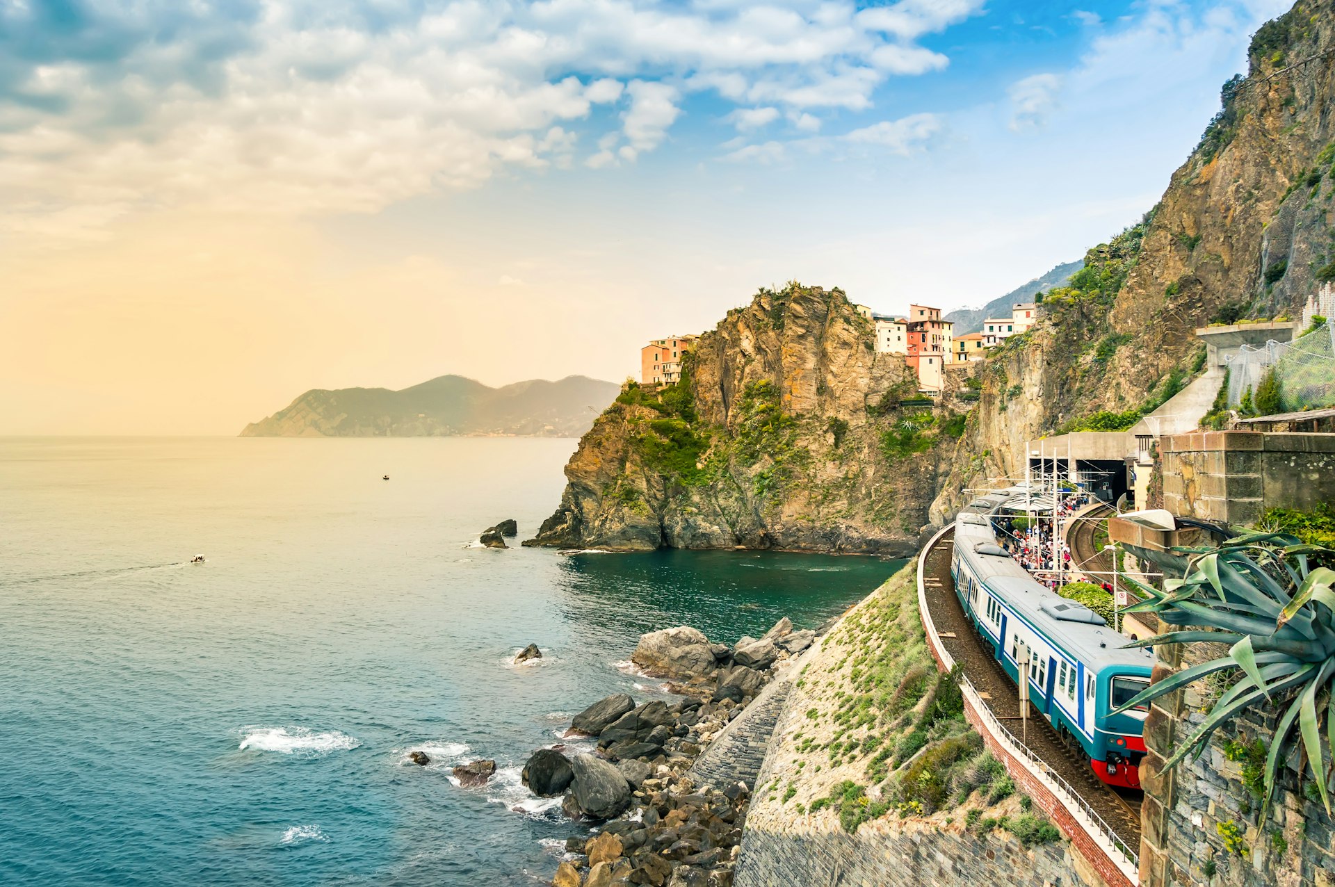 Train station on the coast of Italy in the small village of Manarola with colorful houses on cliff overlooking sea.