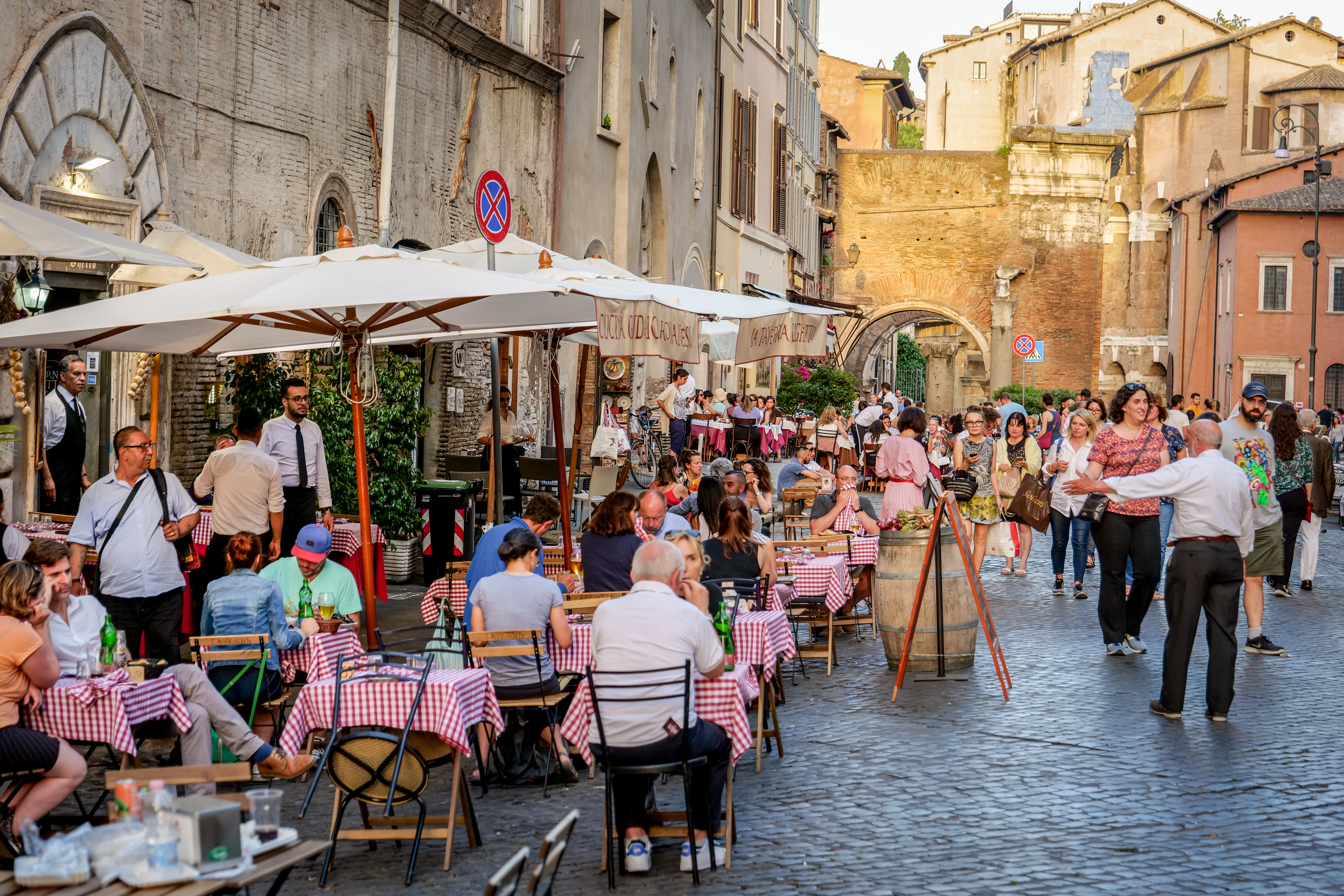 Diners sit at outdoors tables in a lively neighborhood